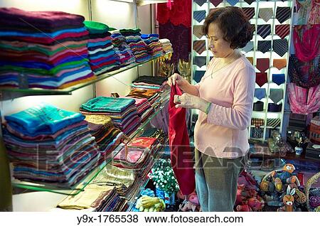 A shop owner shows off silk at the Nunal Boutique silk shop in Hanoi that sells colorful pieces of embroidered silk View Large Photo Image Stock Photo - A shop owner shows off silk at the Nunal Boutique silk shop in Hanoi that sells colorful pieces of embroidered silk. Fotosearch