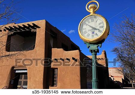 A sidewalk clock with the adobe architecture of New Mexico Museum of Art in the background. Santa Fe. New Mexico. USA. View Large Photo Image Stock Photography - A sidewalk clock with the adobe architecture of New Mexico Museum of Art in the background. Santa Fe. New Mexico. USA.. Fotosearch