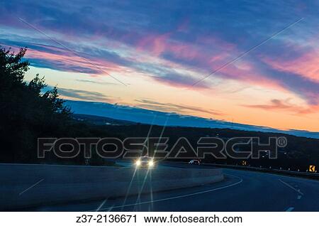 A single car pierces the darkness of night on the highway as dawn breaks out over Nova Scotia, eastern Canada. View Large Photo Image Stock Image - A single car pierces the darkness of night on the highway as dawn breaks out over Nova Scotia, eastern Canada.. Fotosearch