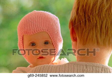 Stock Image - A six months babygirl from the mothers shoulder. Medle. Vasterbotten. Sweden. Fotosearch