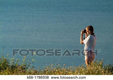 Stock Photo - A sixteen year old girl takes photos near a lake in southern Alberta, Canada. Fotosearch