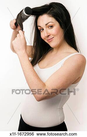 A slim attractive young woman with brown eyes brushing her long brown hair View Large Photo Image Stock Photograph - A slim attractive young woman with brown eyes brushing her long brown hair. Fotosearch