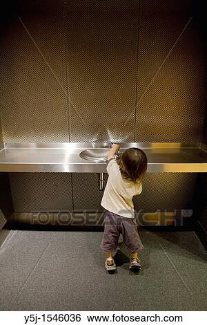 A small child trying to get a drink of water at a water fountain View Large Photo Image Stock Photograph - A small child trying to get a drink of water at a water fountain. Fotosearch