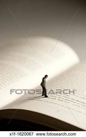a small figure of a man walking on an open book - conceptual image for literacy and reading View Large Photo Image Stock Photo - a small figure of a man walking on an open book - conceptual image for literacy and reading. Fotosearch