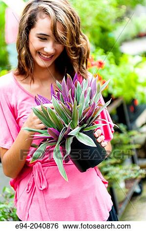 A smiling 14 year old brunette looking at a plant in plant nursery. View Large Photo Image Stock Photograph - A smiling 14 year old brunette looking at a plant in plant nursery.. Fotosearch