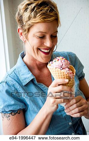 A smiling 44 year old blond woman holding an ice cream cone. View Large Photo Image Stock Photo - A smiling 44 year old blond woman holding an ice cream cone.. Fotosearch