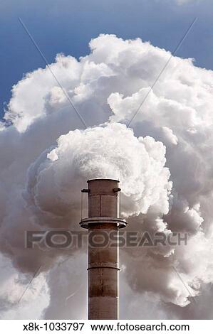 A smokestack billows smoke and steam in rural Nebraska Shot from public highway View Large Photo Image Stock Photo - A smokestack billows smoke and steam in rural Nebraska Shot from public highway. Fotosearch