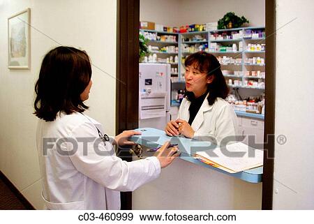 A staff woman physician and a pharmacist talk at the pharmacy window of a neighborhood health clinic in a Vietnamese section of Fullerton, California View Large Photo Image Stock Photo - A staff woman physician and a pharmacist talk at the pharmacy window of a neighborhood health clinic in a Vietnamese section of Fullerton, California. Fotosearch
