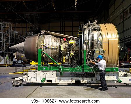 Stock Photo - A staff working on a turbine from a commercial aircraft at a maintenance facility in the SIA Engineering Company in Singapore. Fotosearch