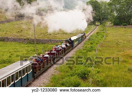A steam train with people on the Ravenglass and Eskdale narrow gauge railway in Cumbria, England, Great britain, Uk View Large Photo Image Stock Image - A steam train with people on the Ravenglass and Eskdale narrow gauge railway in Cumbria, England, Great britain, Uk. Fotosearch