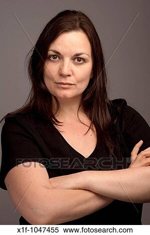 Stock Photography - A stern looking 30 year old woman with her arms folded looking serious. Fotosearch