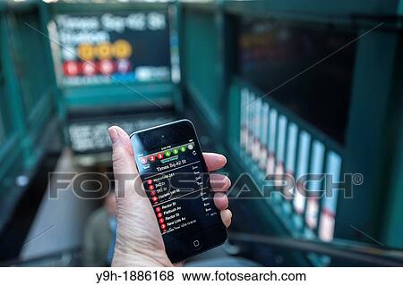 Stock Photo - A subway rider checks the new MTA Subway Time app outside the Times Square station in New York. Fotosearch