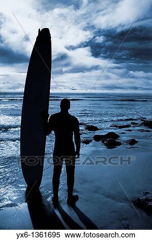 Stock Photography - A surfer preparing for an afternoon of surfing on the Californian coast Santa Cruz, US. Fotosearch