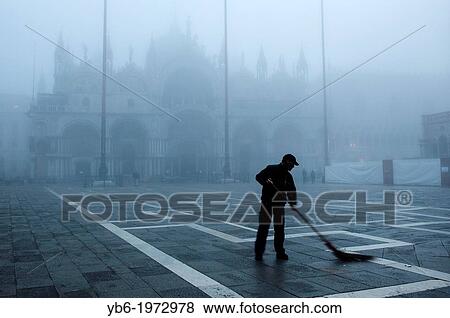 A sweeper works in St. Mark's Square early morning as thick fog covers the city. Venice, Italy. View Large Photo Image Stock Photo - A sweeper works in St. Mark's Square early morning as thick fog covers the city. Venice, Italy.. Fotosearch