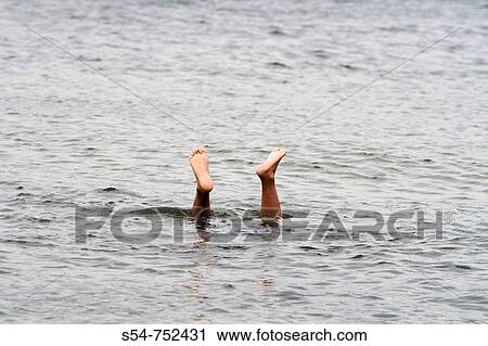 A swimmer sticks her feet out of the water View Large Photo Image Stock Image - A swimmer sticks her feet out of the water. Fotosearch