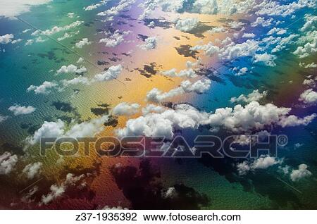 Stock Image - A symphony of color lights up a sunny sky somewhere over the Atlantic Ocean.. Fotosearch