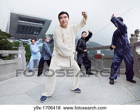 Stock Photo - A Tai Chi Master and his student practice martial arts at The Peak with The Peak Tower in background. Fotosearch