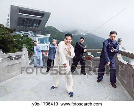 Stock Photo - A Tai Chi Master and his student practice martial arts at The Peak with The Peak Tower in background. Fotosearch