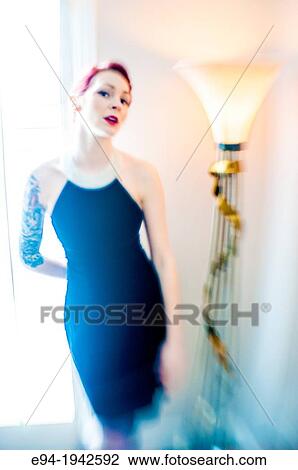 A tattooed 24 year old red headed woman wearing a small black dress indoors. View Large Photo Image Stock Image - A tattooed 24 year old red headed woman wearing a small black dress indoors.. Fotosearch