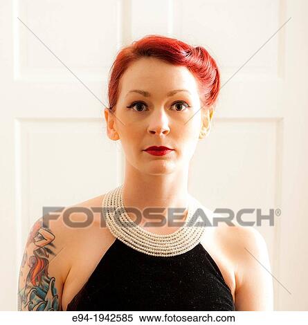 A tattooed 24 year old red headed woman wearing a small black dress indoors. View Large Photo Image Stock Photography - A tattooed 24 year old red headed woman wearing a small black dress indoors.. Fotosearch