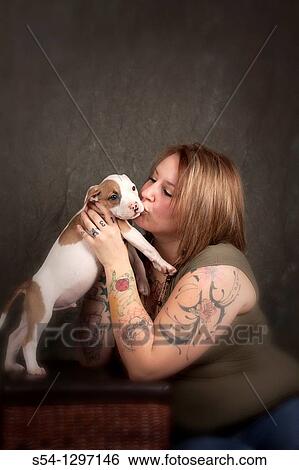 A tattooed woman kisses a nine-week-old pitbull puppy View Large Photo Image Stock Photograph - A tattooed woman kisses a nine-week-old pitbull puppy. Fotosearch