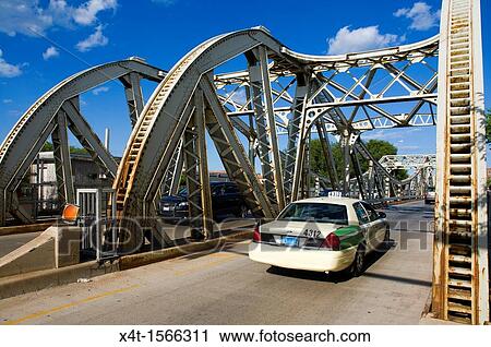 Stock Image - A taxi cab crossing a bridge in Chicago on West Division Street. Fotosearch