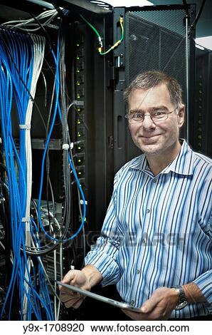 Stock Image - A technician maintaining a giant ethernet hub. Fotosearch