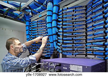 Stock Photo - A technician maintaining a giant ethernet hub. Fotosearch