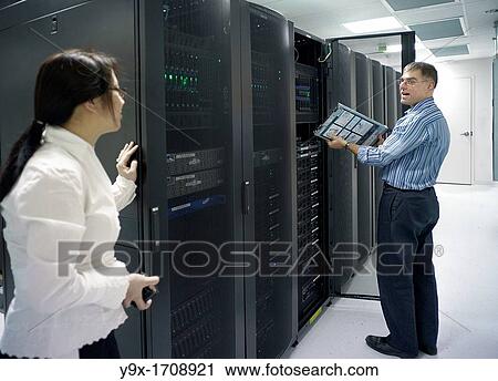 Stock Image - A technician maintaining the server room. Fotosearch
