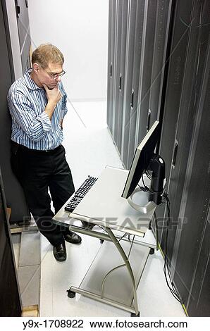 Stock Image - A technician maintaining the server room. Fotosearch
