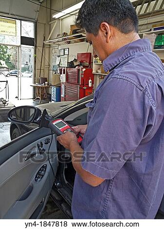 A technitian performes an emission control check on an automobile in California View Large Photo Image Stock Photo - A technitian performes an emission control check on an automobile in California. Fotosearch
