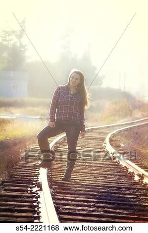 Stock Photo - A teen girl on old railroad tracks in Washington State.. Fotosearch
