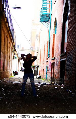 Stock Image - A teen girl standing in an alley in downtown Spokane, Washington, USA.. Fotosearch