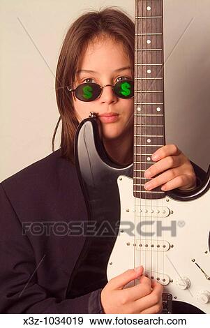 A teenage boy with guitar wearing sunglasses with dollar signs on the lenses View Large Photo Image Stock Photo - A teenage boy with guitar wearing sunglasses with dollar signs on the lenses. Fotosearch