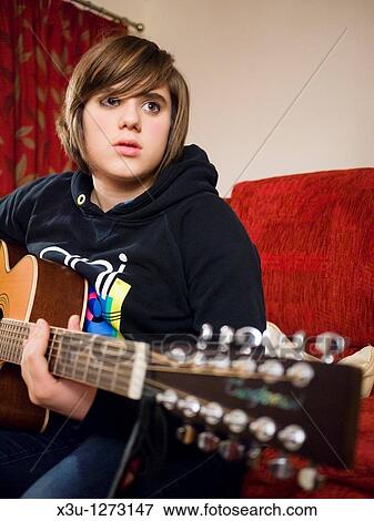 A teenage girl playing a 12 string acoustic guitar View Large Photo Image Stock Photo - A teenage girl playing a 12 string acoustic guitar. Fotosearch