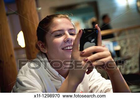 A teenage girl using an Apple iPhone in a cafe, UK View Large Photo Image Stock Image - A teenage girl using an Apple iPhone in a cafe, UK. Fotosearch