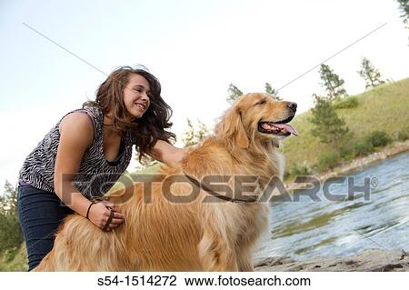 A teenaged Caucasian girl with her Golden Retriever dog at the Spokane River in Spokane, Washington, USA View Large Photo Image Stock Image - A teenaged Caucasian girl with her Golden Retriever dog at the Spokane River in Spokane, Washington, USA. Fotosearch
