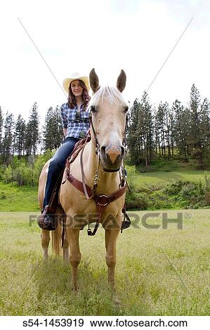 Stock Photo - A teenaged girl riding a horse in Reardan, Washington, USA.. Fotosearch