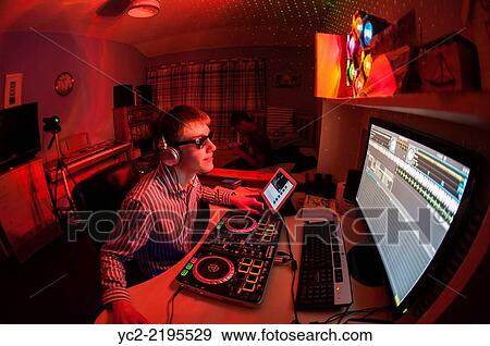 A teenager playing a DJ music set on a livestream internet connection from his bedroom in the Uk. View Large Photo Image Stock Photo - A teenager playing a DJ music set on a livestream internet connection from his bedroom in the Uk.. Fotosearch