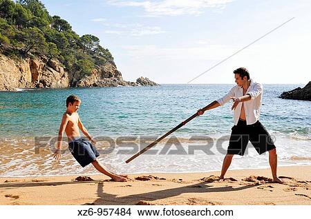 A teenager playing with his older brother at the beach View Large Photo Image Picture - A teenager playing with his older brother at the beach. Fotosearch