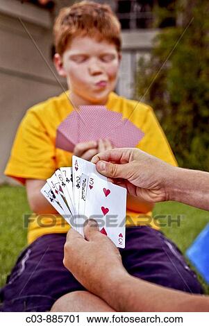 A ten-year-old Caucasian red-headed boy evaluates his hand as he plays cards outdoors in Laguna Niguel, CA Note partner's cards in foreground View Large Photo Image Stock Image - A ten-year-old Caucasian red-headed boy evaluates his hand as he plays cards outdoors in Laguna Niguel, CA Note partner's cards in foreground. Fotosearch