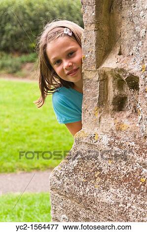 Stock Photo - A ten year old girl outside in a churchyard in the Uk. Fotosearch