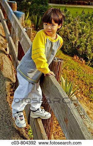 Stock Image - A three-year-old? blended? Asian-Caucasian boy amuses himself on a sunny afternoon in a Laguna Beach, CA, playground. Fotosearch