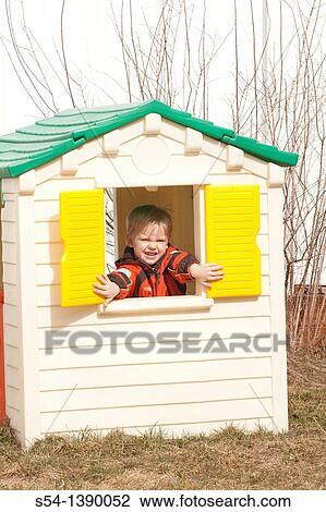 Stock Image - A three-year-old boy in a playhouse. Fotosearch