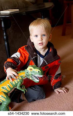 A three-year-old boy plays with a toy dinosaur View Large Photo Image Stock Image - A three-year-old boy plays with a toy dinosaur. Fotosearch
