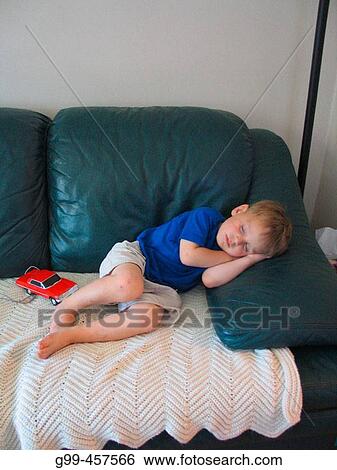 A three year old boy sleeps at home on a couch and with a little red car View Large Photo Image Stock Photograph - A three year old boy sleeps at home on a couch and with a little red car. Fotosearch