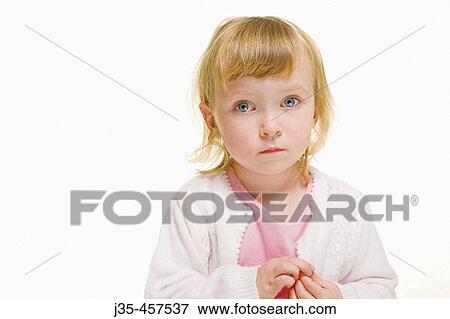 A three year old girl with blonde hair wearing a white sweater and a pink top looks into camera with a concerned expression while holding her hands together. View Large Photo Image Stock Photo - A three year old girl with blonde hair wearing a white sweater and a pink top looks into camera with a concerned expression while holding her hands together.. Fotosearch