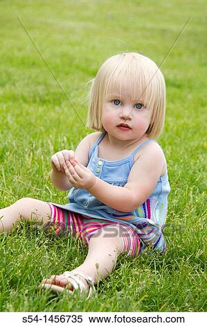 A toddler at the park, sitting in the grass. View Large Photo Image Stock Photography - A toddler at the park, sitting in the grass.. Fotosearch