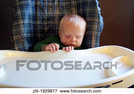 A toddler, Chase Adams, catches forty winks in his high chair at home View Large Photo Image Stock Photo - A toddler, Chase Adams, catches forty winks in his high chair at home. Fotosearch
