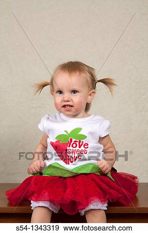 Stock Photo - A toddler in a watermelon outift indoors. Fotosearch